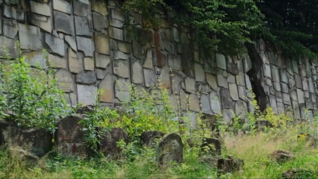 Memorial wall in Kazimierz Dolny, Poland - Scene from Karen Goodman's film "Dybbuk Remix: Dancing Between Worlds" - Screenshot by LADC.